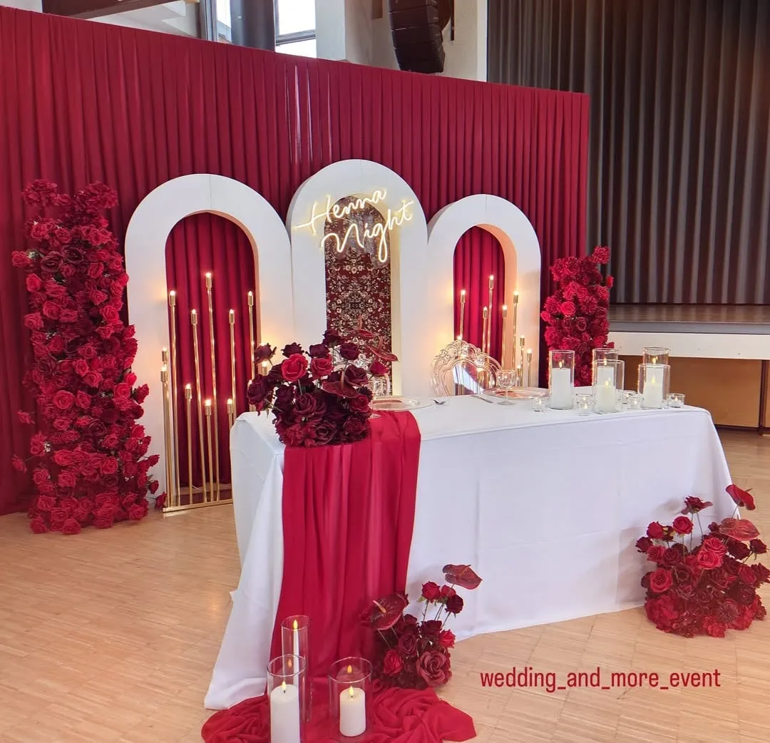 Henna night backdrop with red accents and a white tablecloth