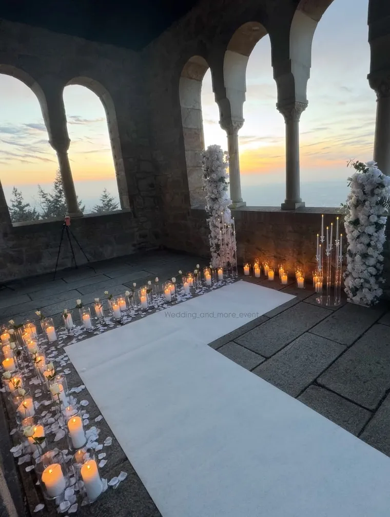 Heiratsantragsdekoration mit weißen Blumen und Kerzen in Zylindervasen